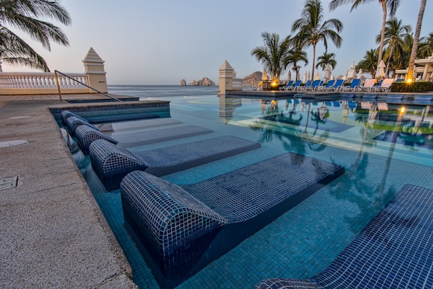 Foto gratuita tumbonas azules en la piscina