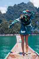 Foto gratuita turismo de blogger joven asiática feliz mujer en traje de seda y bufanda y gafas de sol de vacaciones viajan alrededor de tailandia en barco asiático, parque nacional khao sok.