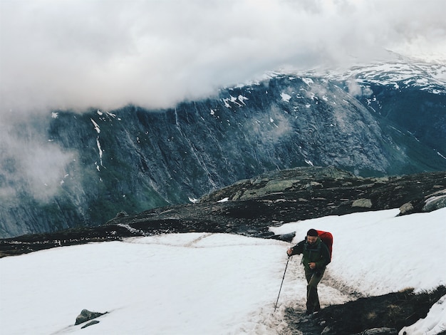 Turismo camina a través de la nieve en las montañas