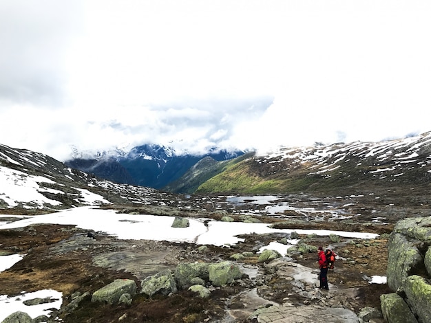 Turismo camina a través de la nieve en las montañas