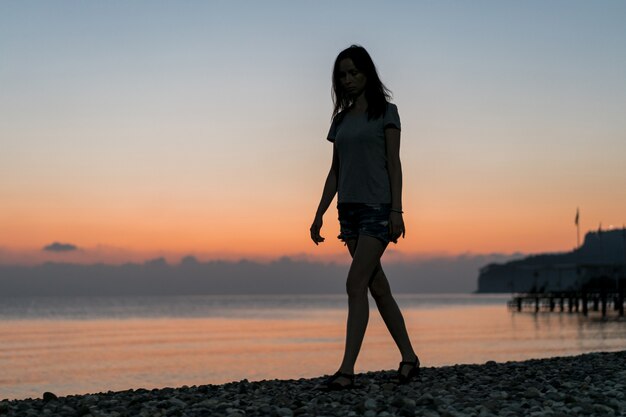 Turista al amanecer caminando sobre arena