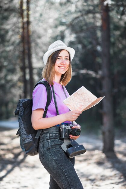 Turista alegre con mapa y cámara