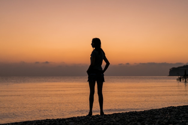 Turista en el amanecer desde detrás de tiro