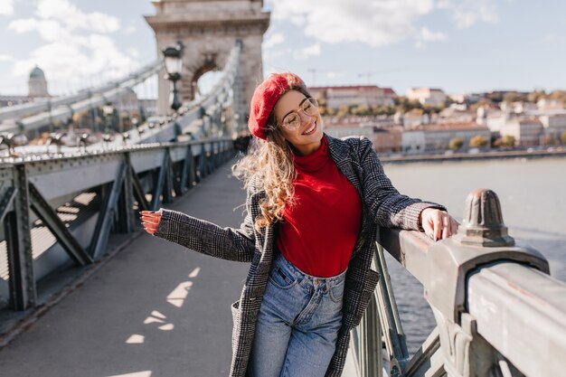 Turista bastante femenina en traje casual divirtiéndose en la ciudad de su sueño