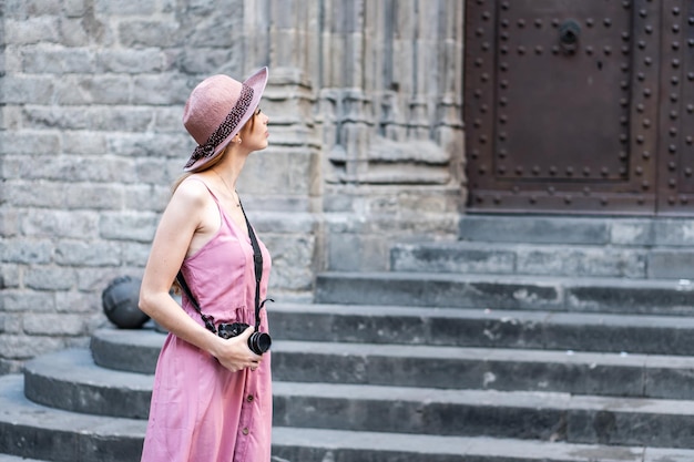 Turista bonita rubia caucásica con un sombrero tomando fotos de la ciudad