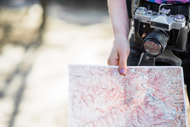 Turista de cultivo con cámara y mapa