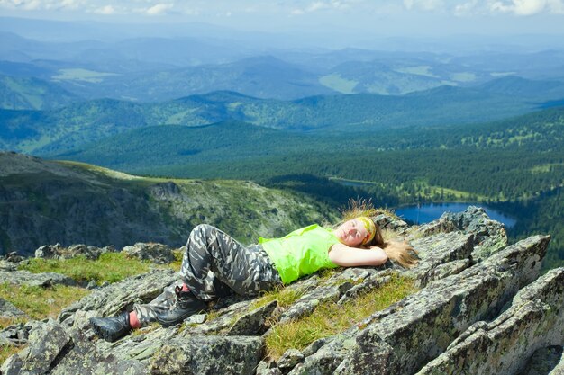 Turista descansando en el pico de montaña