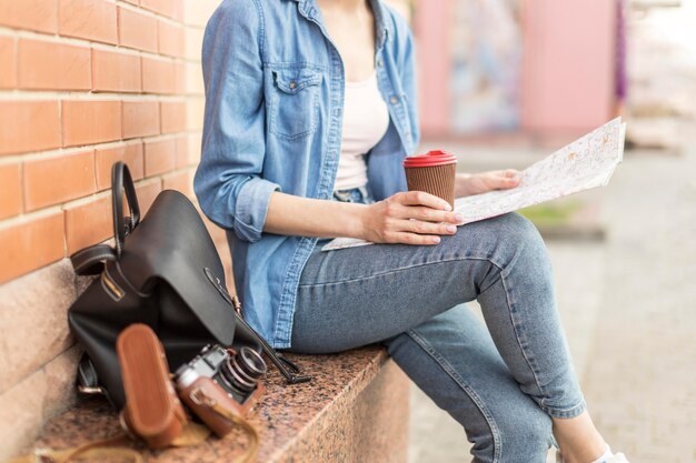 Turista disfrutando de café mientras revisa el mapa