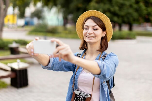 Turista elegante con sombrero tomando fotos