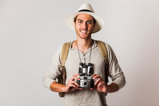 Turista estilo hipster sonriente con cámara