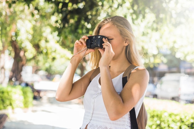 Foto gratuita turista femenino fotografiando al aire libre