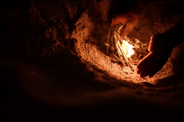 Foto gratuita turista hace un fuego en la playa.