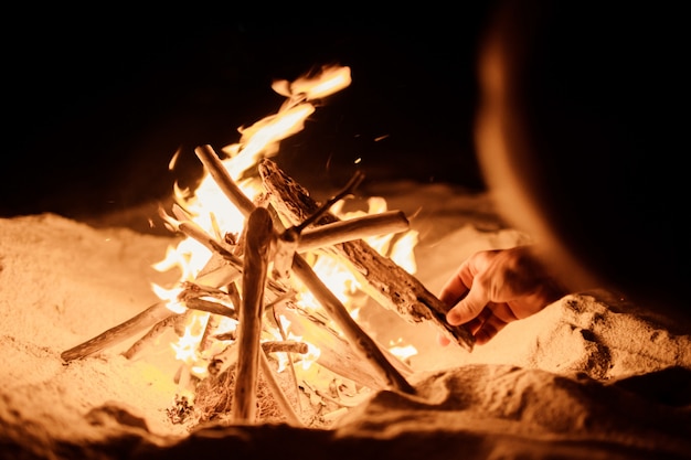 Foto gratuita turista hace un fuego en la playa.