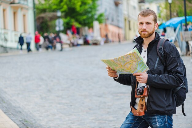 Turista hombre con cámara y mapa