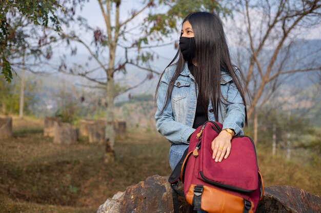 Turista de mujer asiática con mascarilla. Concepto de viaje del virus de la gripe coronavirus