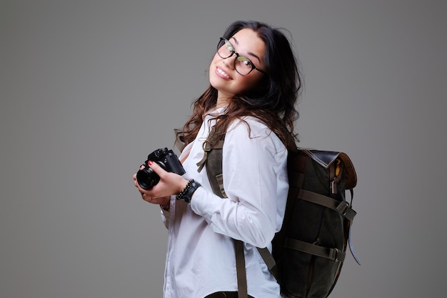 Turista positiva con cámara fotográfica y mochila de viaje.