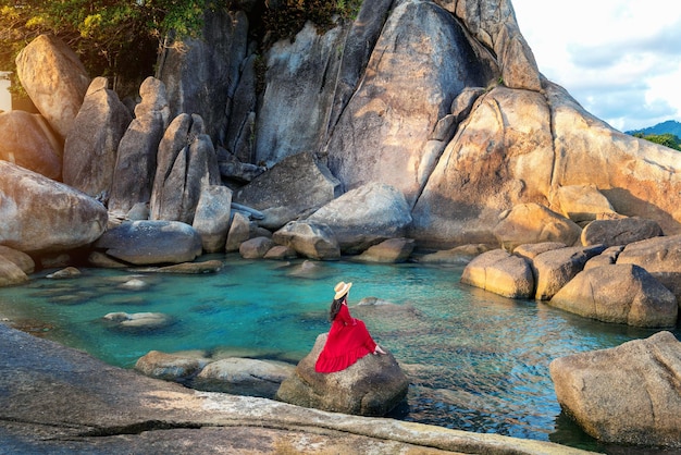 Turista sentado en la roca cerca del abuelo y el abuelo rock Hin Ta y Hin Yai Rocks en la playa Lamai Koh Samui Tailandia
