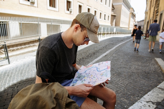 Turista teniendo en cuenta el mapa de la ciudad en Roma