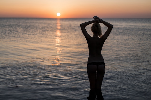 Foto gratuita turista en traje de baño mirando el amanecer