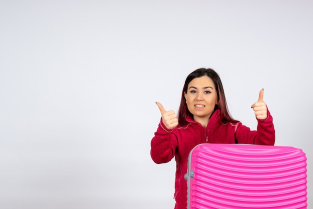 Turista de vista frontal con bolsa rosa sobre una pared blanca