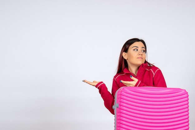 Turista de vista frontal con bolsa rosa sobre pared blanca