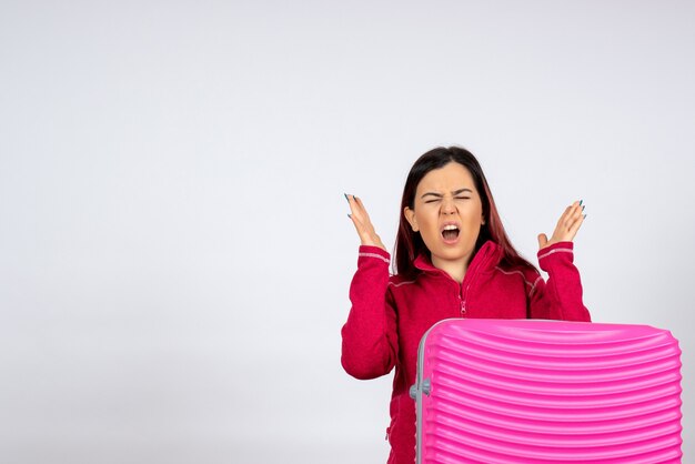 Turista de vista frontal con bolsa rosa sobre pared blanca