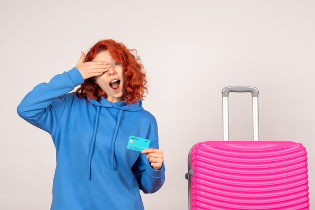 Turista de vista frontal con tarjeta bancaria y bolso rosa