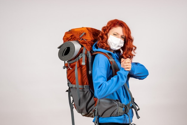 Turista de vista frontal en viaje de montaña en máscara con mochila