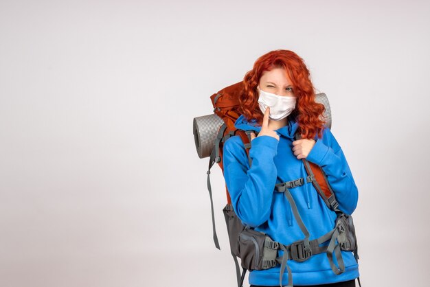 Turista de vista frontal en viaje de montaña en máscara con mochila