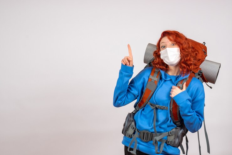 Turista de vista frontal en viaje de montaña en máscara con mochila