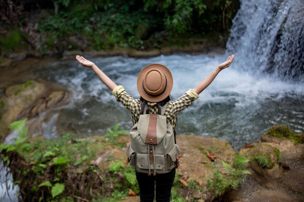 Las turistas están felices y descansadas en la cascada.