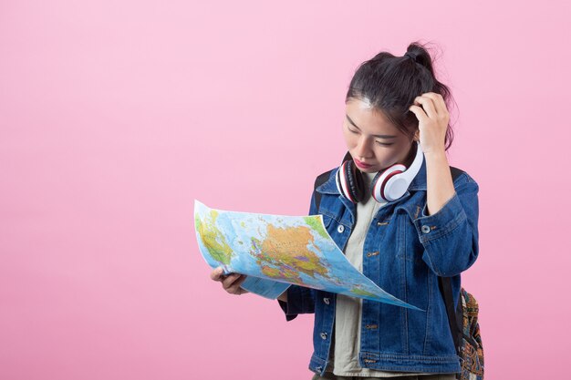 Turistas femeninos en el estudio en un fondo rosado.