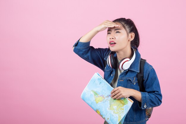 Turistas femeninos en el estudio en un fondo rosado.