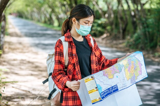 Las turistas se paran y miran el mapa en el camino.