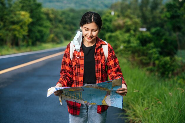 Las turistas se paran y miran el mapa en el camino.