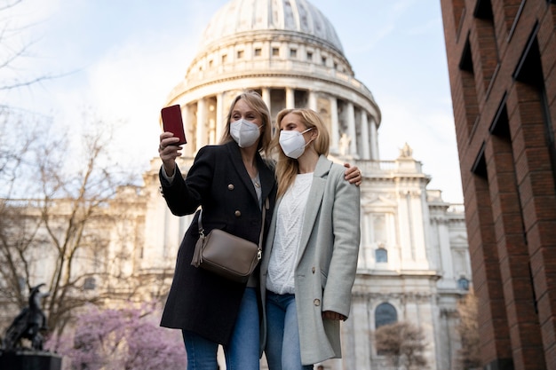 Foto gratuita turistas que visitan la ciudad y usan máscara de viaje