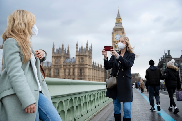 Foto gratuita turistas que visitan la ciudad y usan máscara de viaje