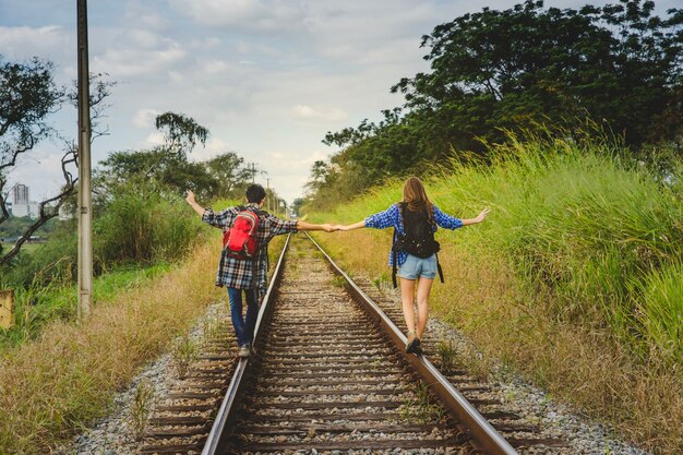 Turistas tomándose las manos en vías de tren
