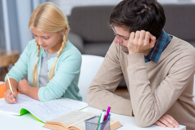 Tutor aburrido y niña aprendiendo