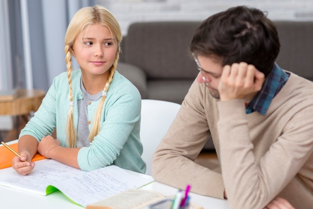 Foto gratuita tutor apoyándose en su mano junto a estudiante