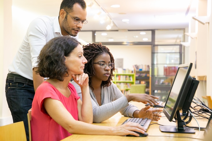 Foto gratuito tutor ayudando a estudiantes en clase de computación