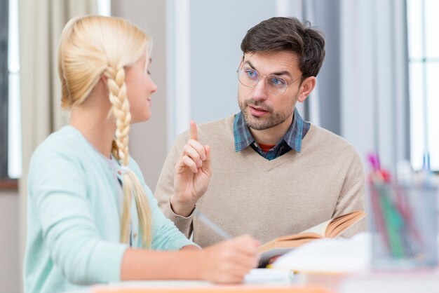 Tutor y niña en casa enseñando