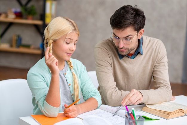 Tutor y niña en casa estudiante teniendo una idea