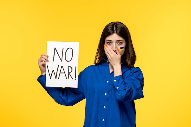 Ucrania conflicto ruso banderas de niña bonita joven en las mejillas fondo amarillo llorando sin guerra