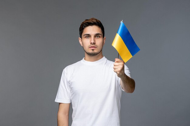 Ucrania conflicto ruso bastante lindo guapo en camisa blanca con bandera ucraniana levantada