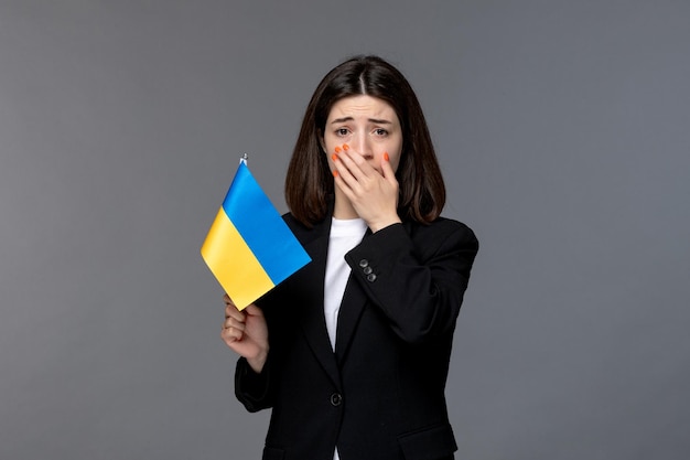 Ucrania conflicto ruso linda mujer joven de cabello oscuro en blazer negro llorando cubriendo la boca malestar