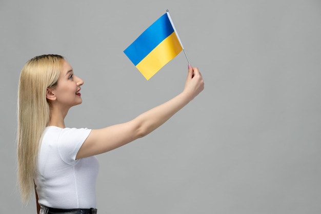 Foto gratuita ucrania conflicto ruso rubia linda chica con lápiz labial rojo y bandera ucraniana feliz