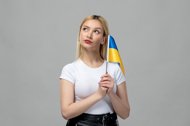 Ucrania conflicto ruso rubia linda chica con lápiz labial rojo y bandera ucraniana pensando