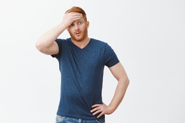 Uf, casi atrapado. Retrato de lindo chico cansado con cabello rojo sintiéndose aliviado, limpiando el sudor de la frente, mirando a un lado con expresión exhausta, superando todos los problemas y exhalando