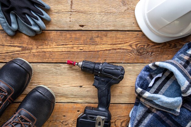 Uniforme y herramientas de construcción en la vista superior de la mesa de madera